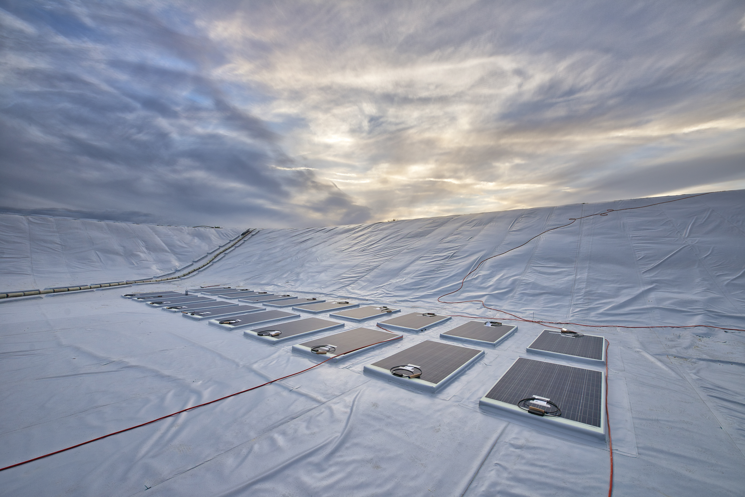 Das Wasserreservoir in Limassol, Zypern, hat eine Größe von 6.500 Quadratmetern, ist 4,50 Meter tief und wurde vollständig von einer funktionalen Folie abgedeckt. Die auf der Spezialfolie integrierten Photovoltaik-Module erzeugen elektrischen Strom aus nachhaltiger <a href=