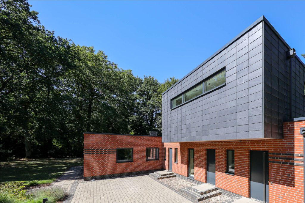 Ungewöhnliche Sanierung: Aus Winkelbungalow mit Walmdach wird ein modernes Einfamilienhaus. Foto: Rathscheck Schiefer