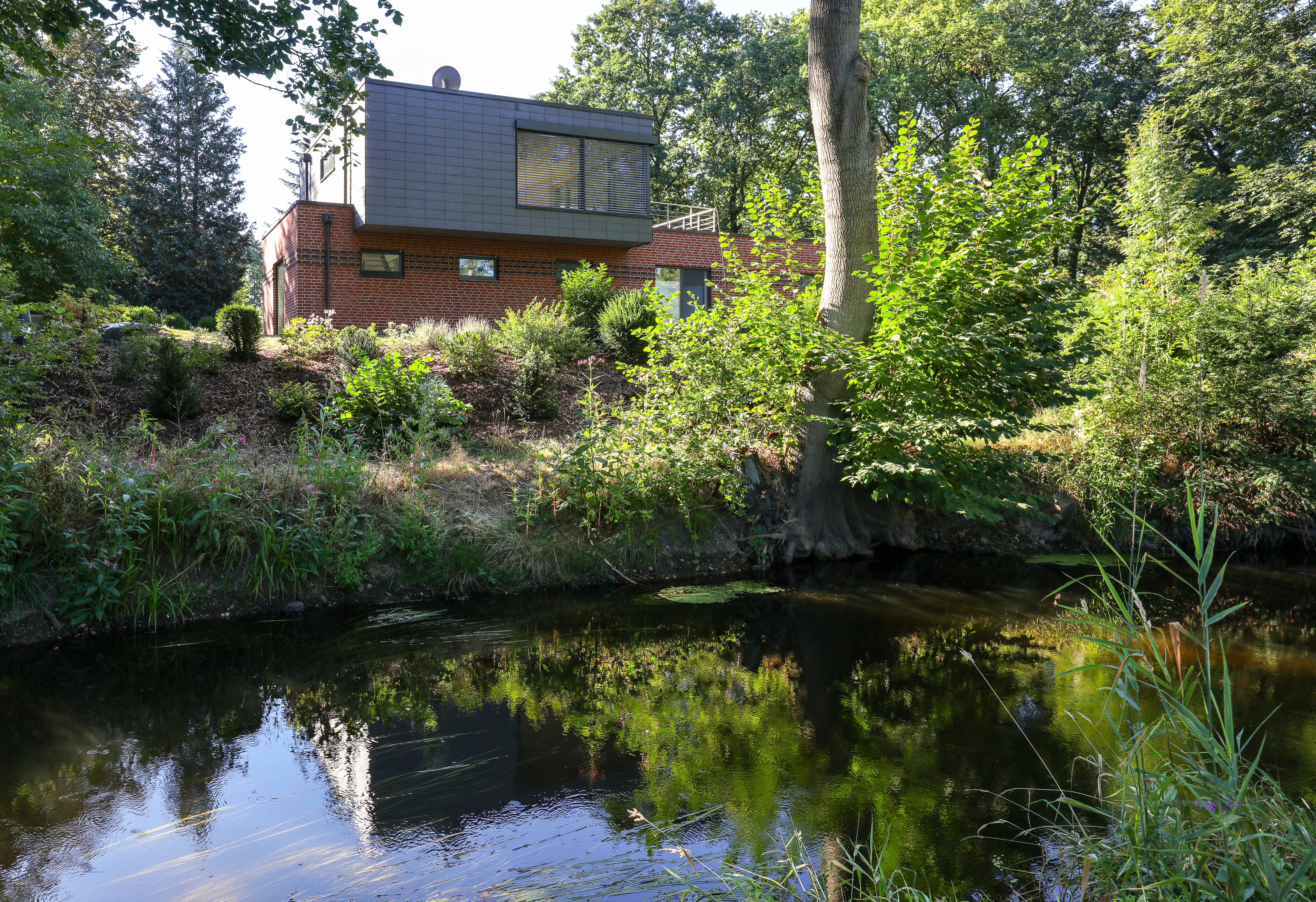 Der Bach Lachte fließt durch den Naturpark Südheide und ist an diesem Haus ein Highlight. Foto: Rathscheck Schiefer